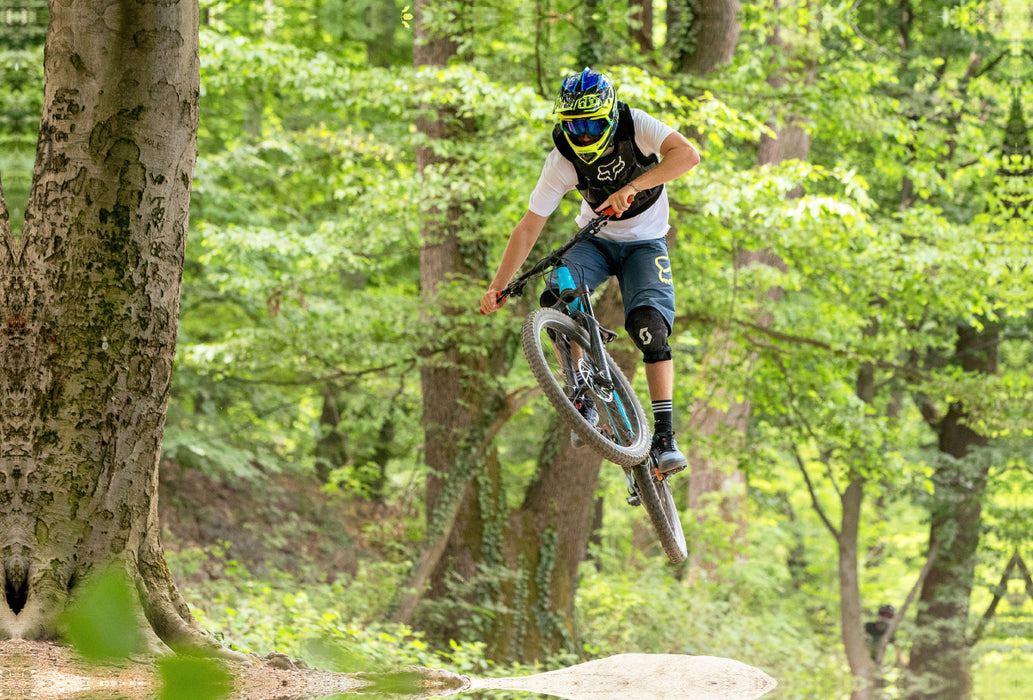 Premium Textil-Leinwand Ambitionierter Mountain Biker während eines Sprungs.