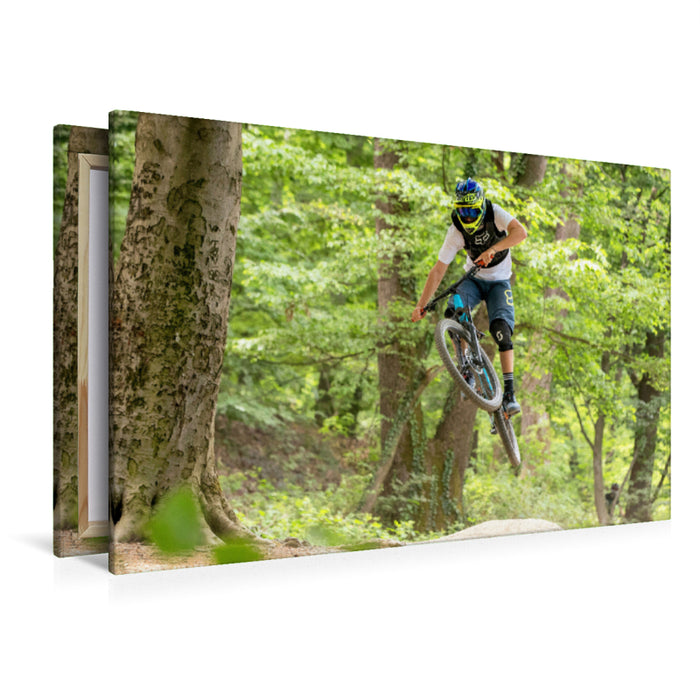 Premium Textil-Leinwand Ambitionierter Mountain Biker während eines Sprungs.