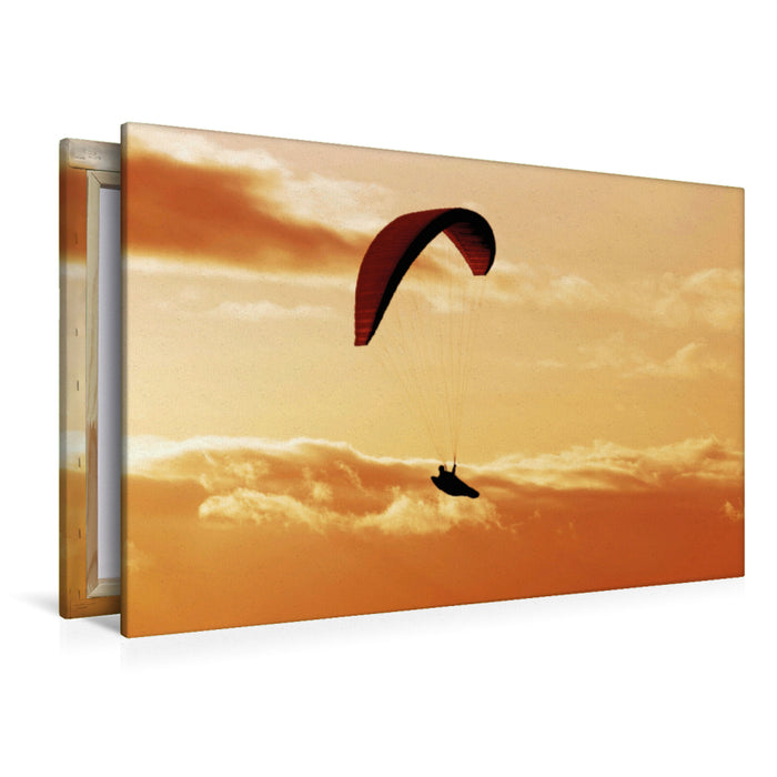 Premium Textil-Leinwand Premium Textil-Leinwand 120 cm x 80 cm quer Paragliding im warmen Licht der untergehenden Sonne.